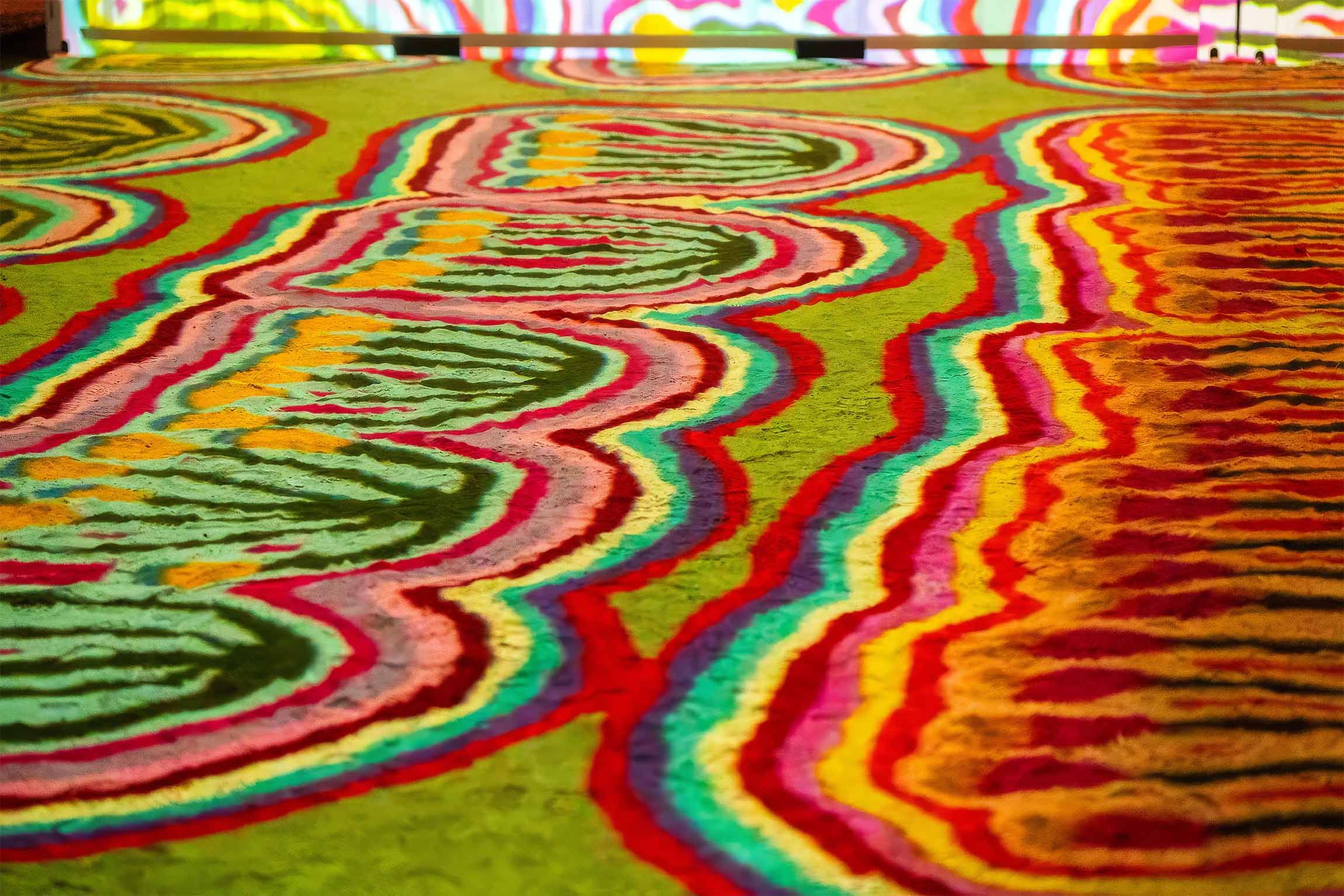 Colorful abstract pattern with wavy lines and vibrant hues, including green, red, blue, and yellow, creating an intricate, eye-catching design.